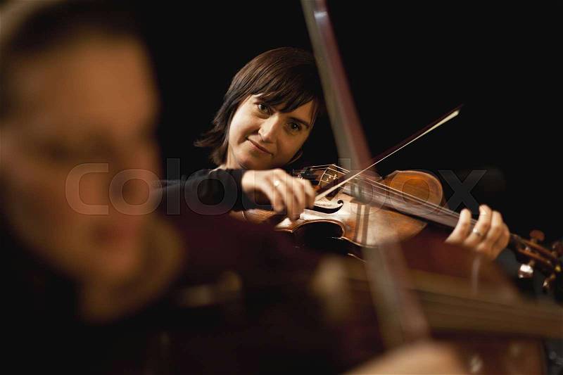 Violin players in orchestra, stock photo