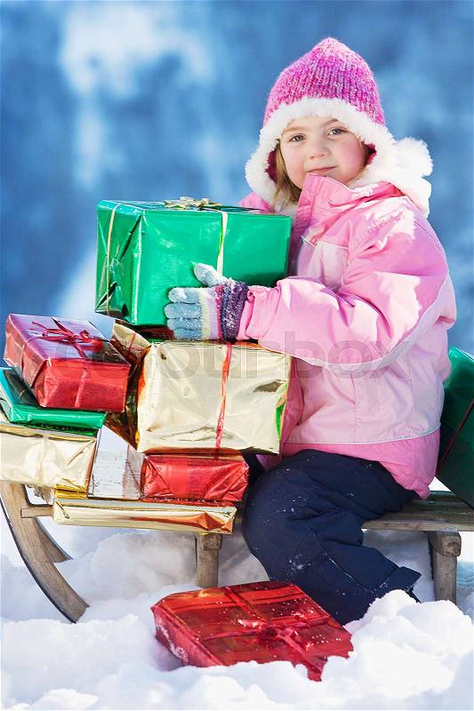 Portrait of girl on sledge with presents, stock photo