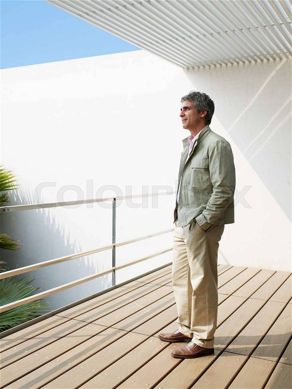 Man standing on balcony, stock photo