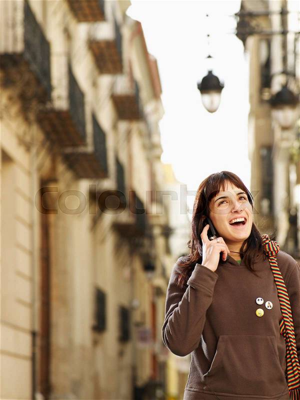Young woman on mobile phone in street, stock photo