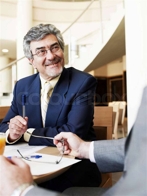 Senior businessman in meeting smiling, stock photo