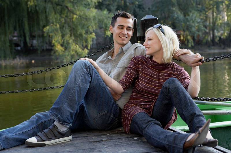 Couple on a dock smiling and relaxing, stock photo