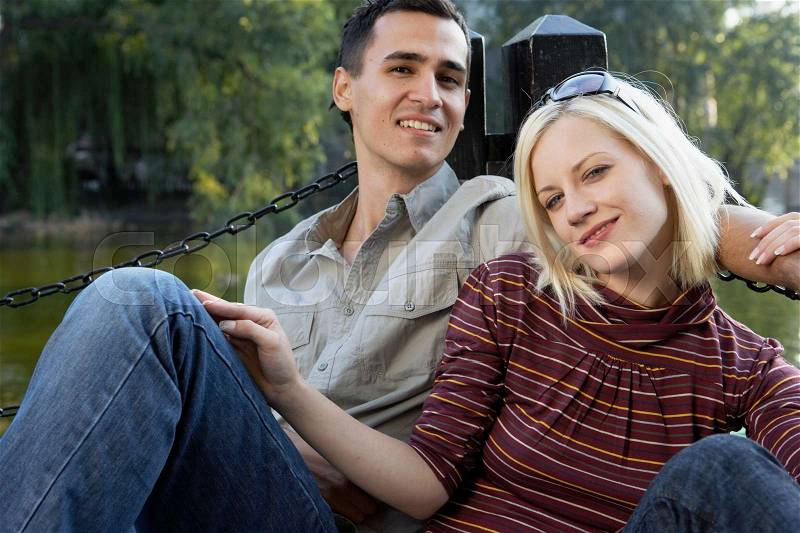 Couple on a dock smiling and relaxing, stock photo