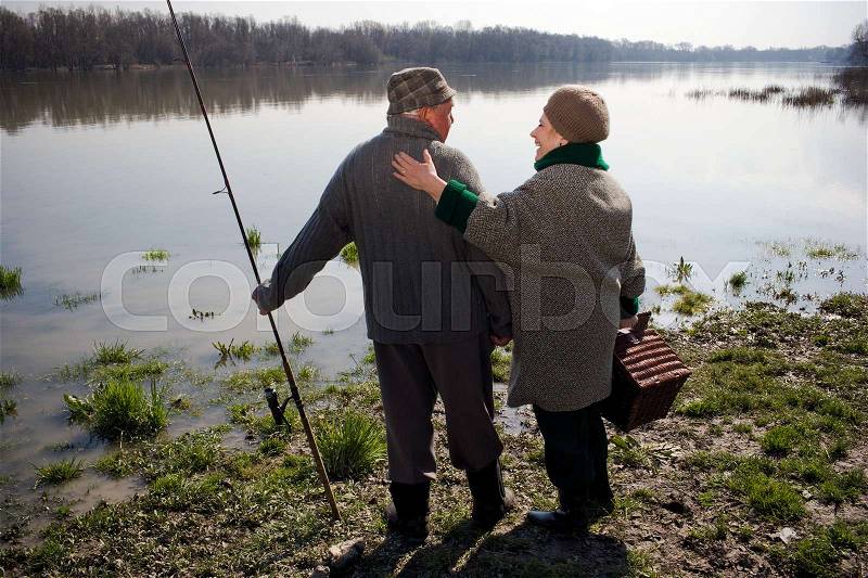 Senior couple holding fishing rod, stock photo