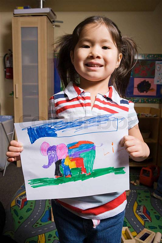 A girl showing a pencil drawing of an elephant, stock photo