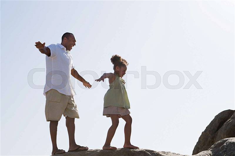 Father and daughter walking on rocks, stock photo