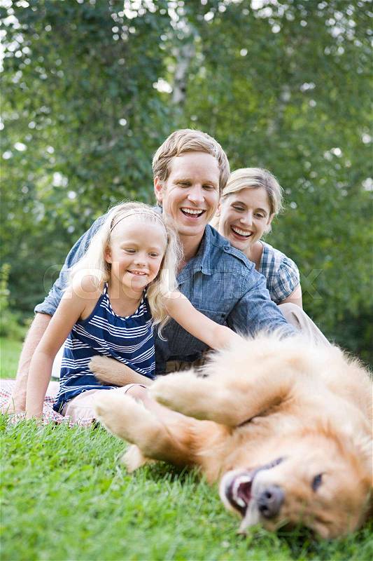 Family in the park with golden retriever, stock photo
