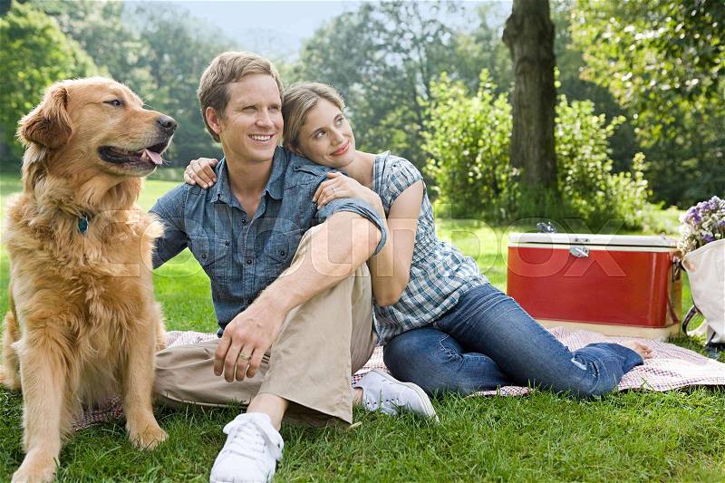 Couple having picnic with their dog, stock photo