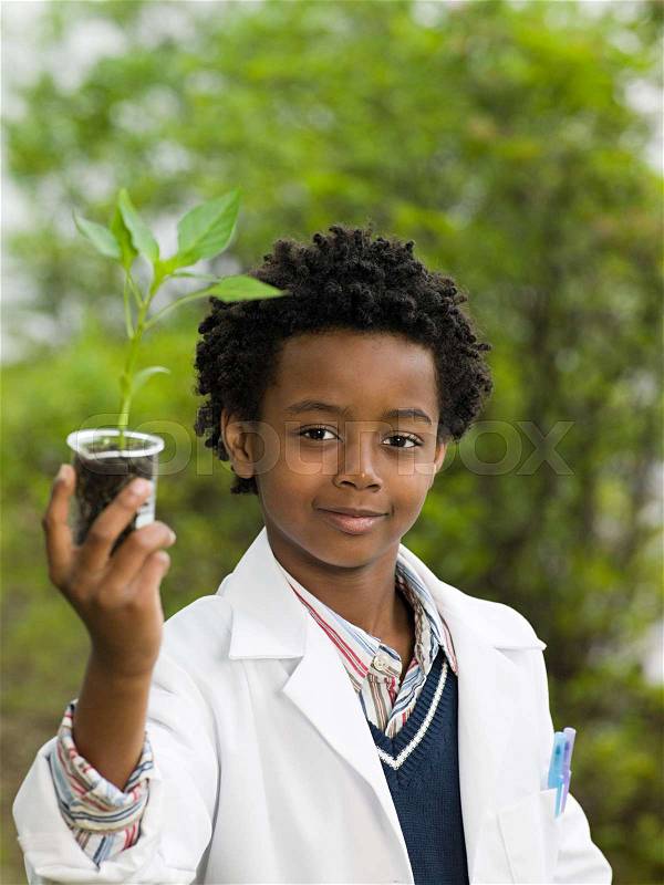 A boy holding a plant in a volumetric flask, stock photo
