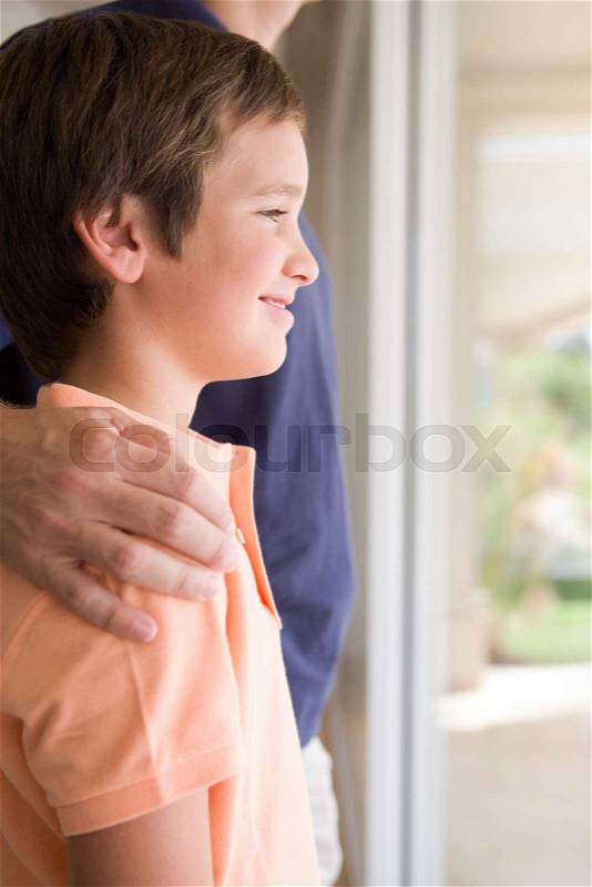 Boy with father\'s hand on his shoulder, stock photo