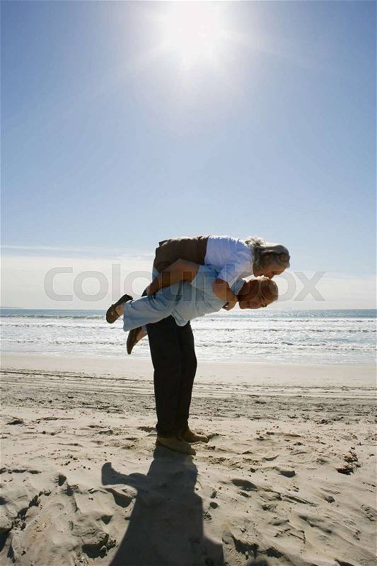 Senior man carrying woman on back, stock photo