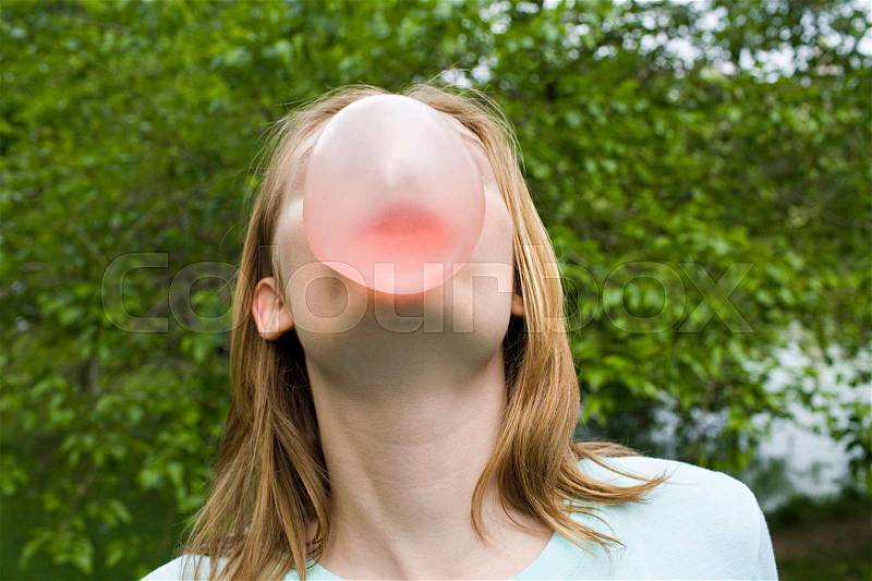 Teenage girl blowing a bubble gum bubble, stock photo