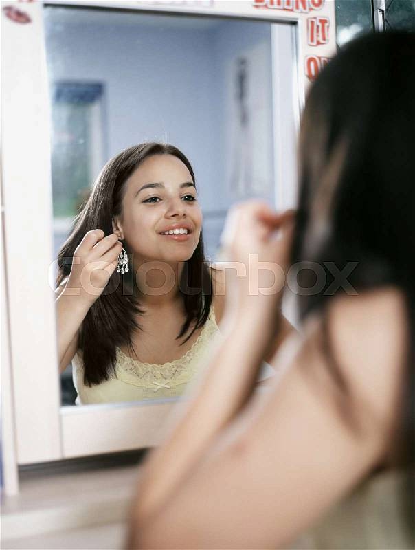 Girl looking in mirror, stock photo