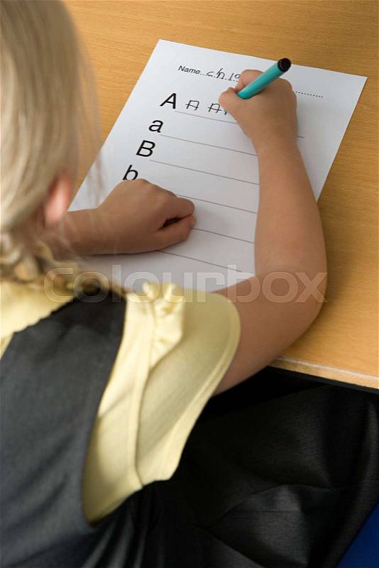 Girl writing alphabet, stock photo