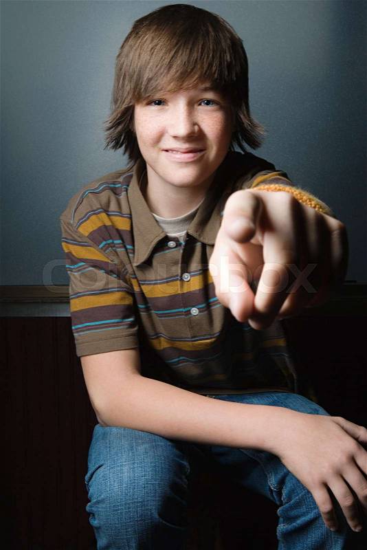 Teenage boy pointing at camera, stock photo