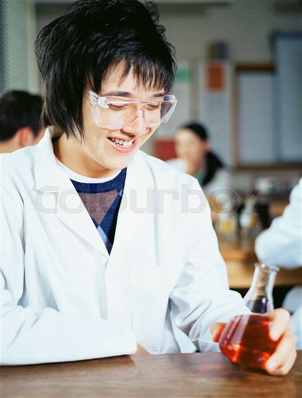 Teenage boy in chemistry class, stock photo