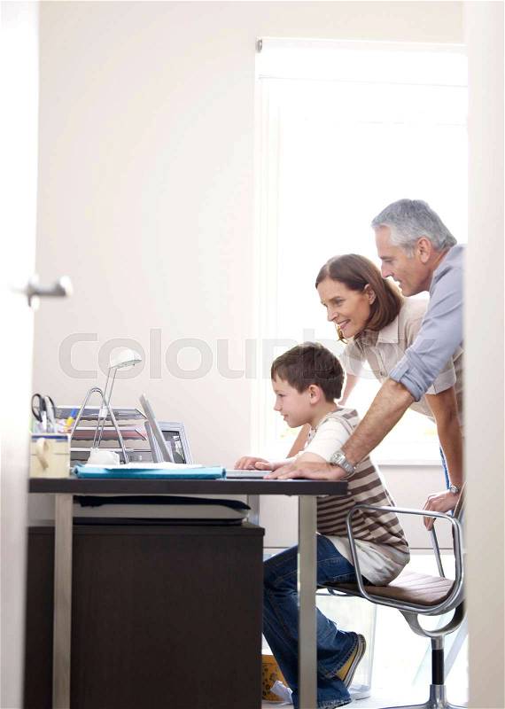 Family at laptop in home office, stock photo
