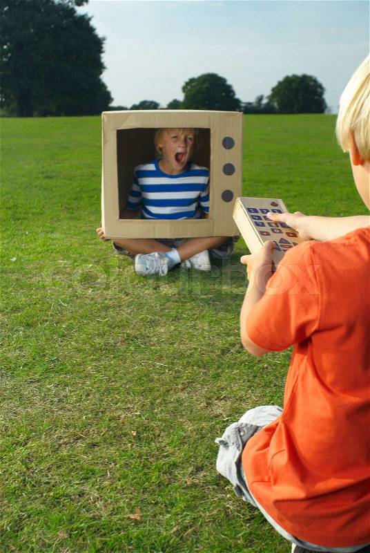 Boy screaming from inside cardboard tv, stock photo