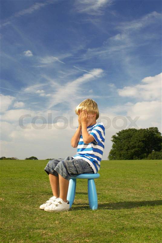 Boy sitting on stool, stock photo