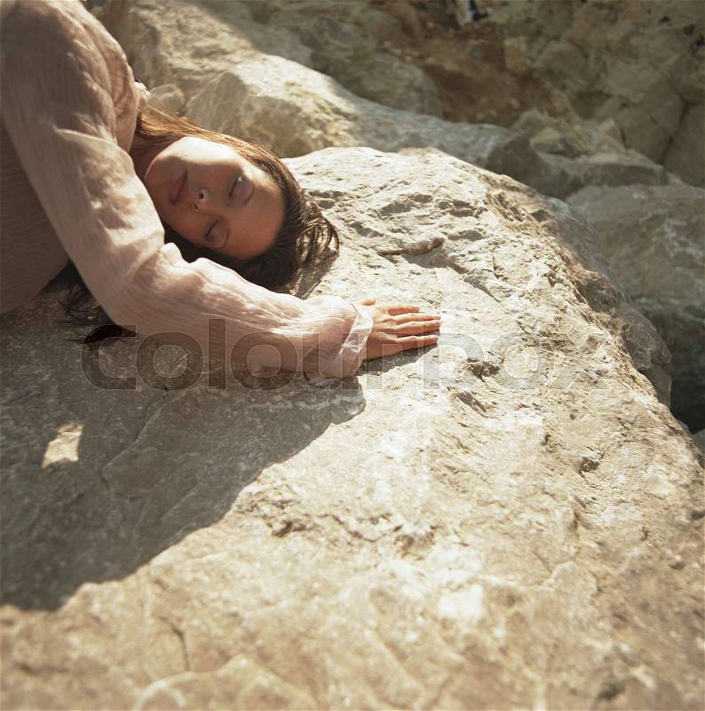 Woman lying on warm rock, stock photo