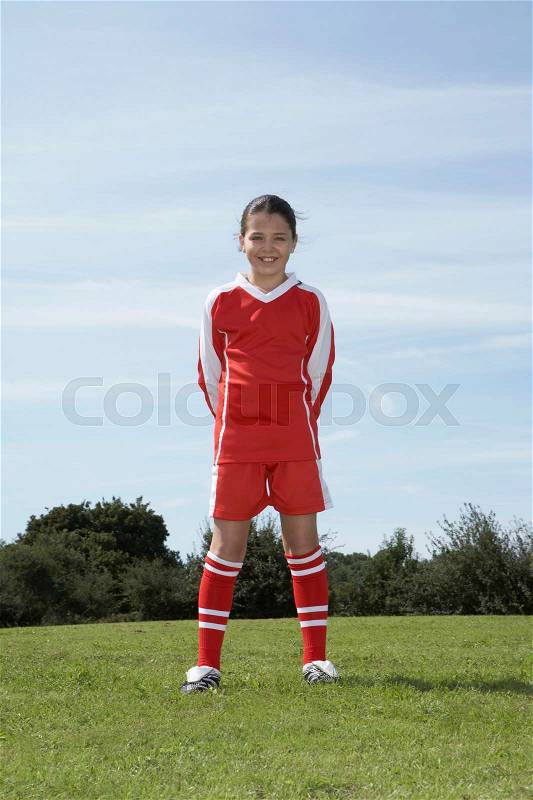 Female footballer standing, stock photo