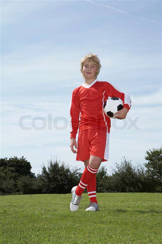 Young Male footballer holding a ball, stock photo