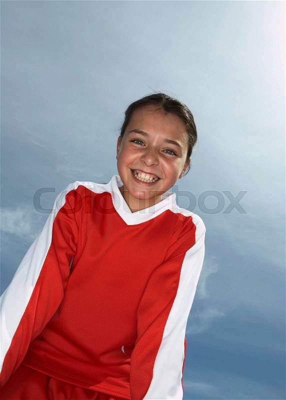 Low viewpoint of young female footballer, stock photo