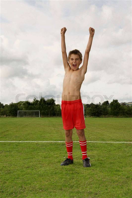 Young footballer with arms raised, stock photo