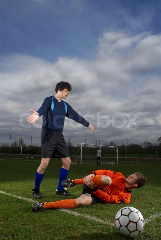 Footballer fouled by another player, stock photo
