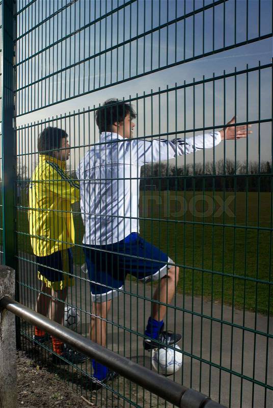 Two footballers watching game, stock photo