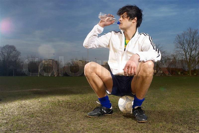 Footballer drinking water, stock photo