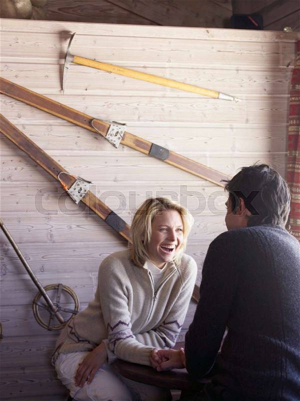 Man and woman sitting at ski lodge table, stock photo