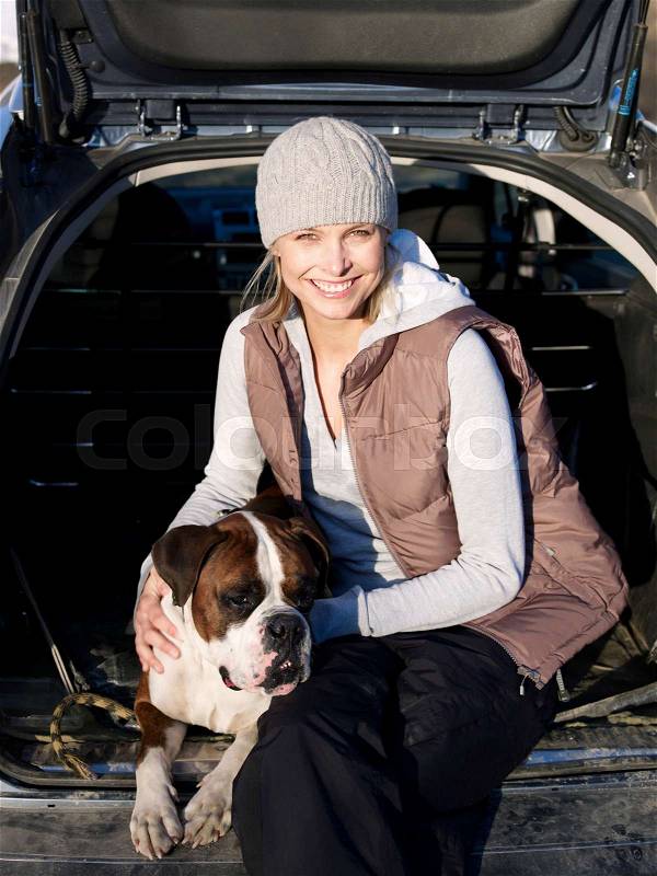 Woman in back of car with dog, stock photo