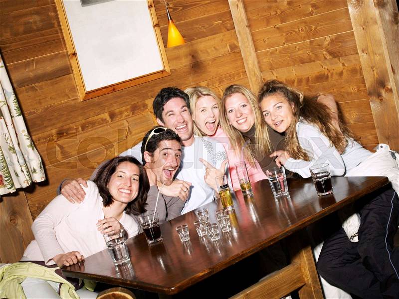 Friends laughing in ski lodge bar, stock photo