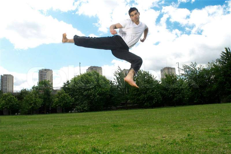 Jumping kick in park, stock photo
