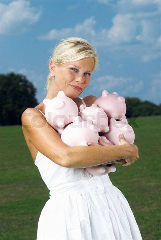 Woman holding piggy banks, stock photo