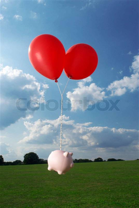 Piggy bank tied to balloons, stock photo
