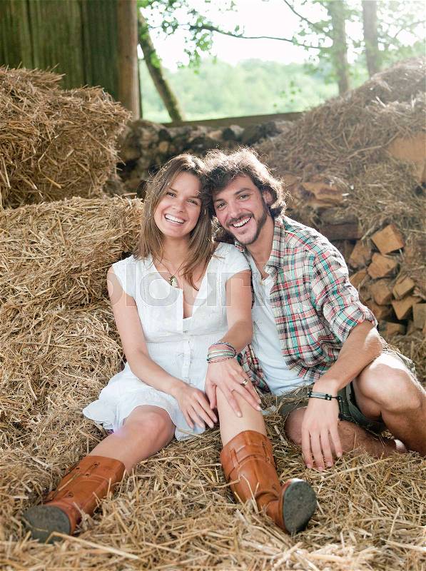 Man and woman lying in hay barn, stock photo