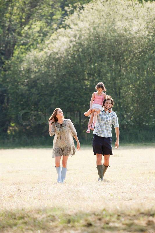 Family walking through country field, stock photo