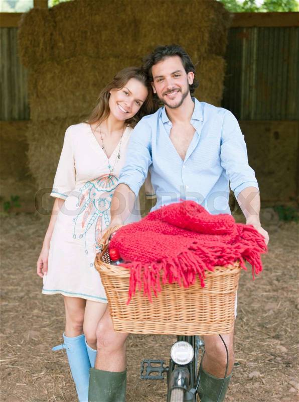Couple in on bike with picnic basket, stock photo