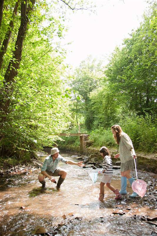 Family playing in country stream, stock photo