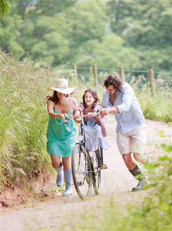 Family with daughter on bicycle, stock photo