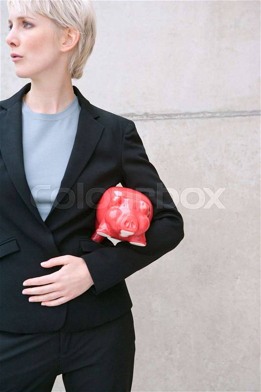 Woman in suit with piggy bank, stock photo