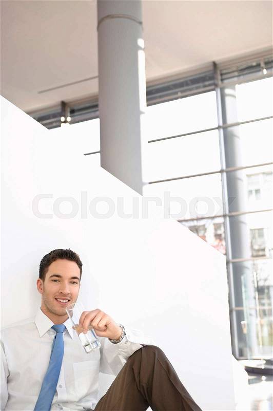 Man with glass of water smiling in break, stock photo