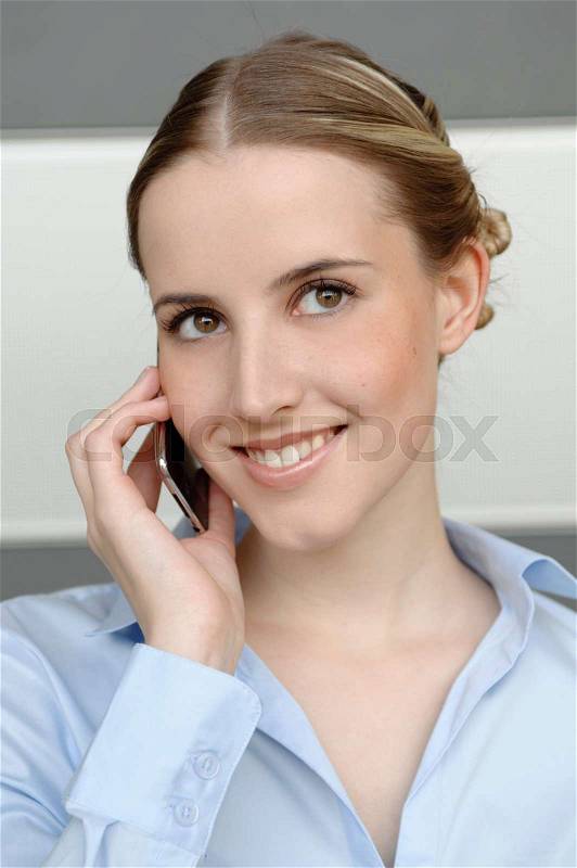 Friendly woman using mobile in office, stock photo