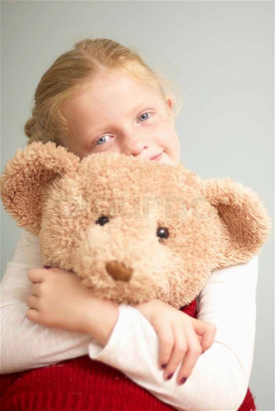 Young girl cuddling teddy bear, stock photo