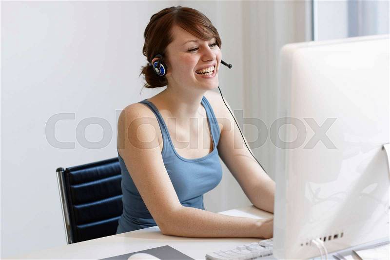 Women with Headset working on Computer, stock photo