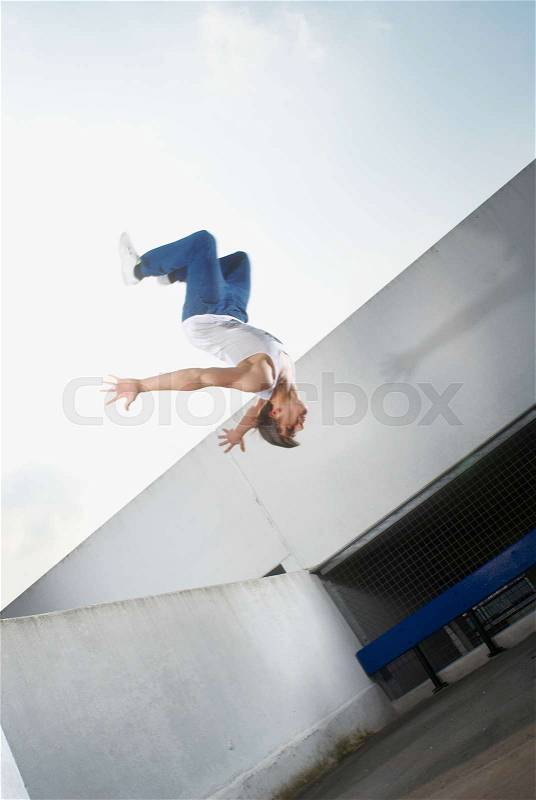 Man jumping on urban rooftop, stock photo