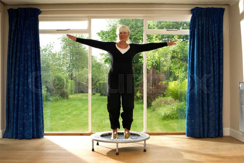 Woman jumping on exercise trampoline, stock photo
