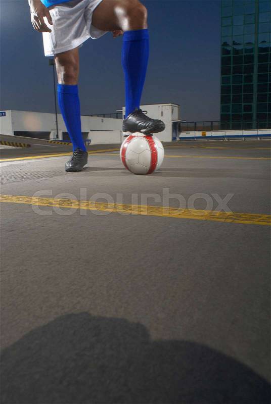 Soccer player with ball on rooftop, stock photo